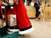 A dog waits to be groomed near some items from the Holiday Tails Collection at a Petco Animal Supplies Inc. store in Seminole, Fla.