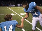 Hockinson’s Levi Crum (14) and Jon Domingos (42) encourage each another before the first round of the 2A state football playoffs against Washington.