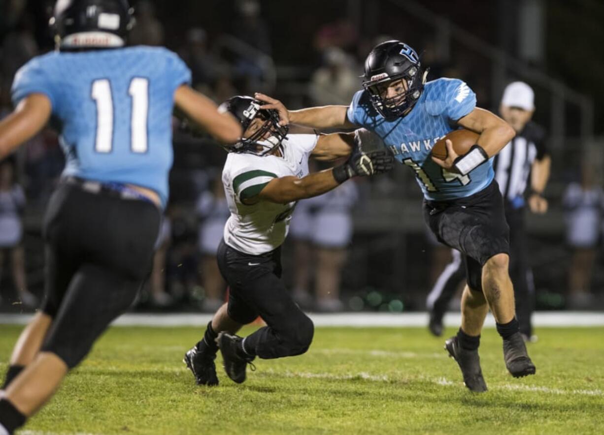 Hockinson's Levi Crum (14) stiff-arms Woodland's Elijua Schultz (22) during Friday night's game in Hockinson on Sept. 28, 2018.