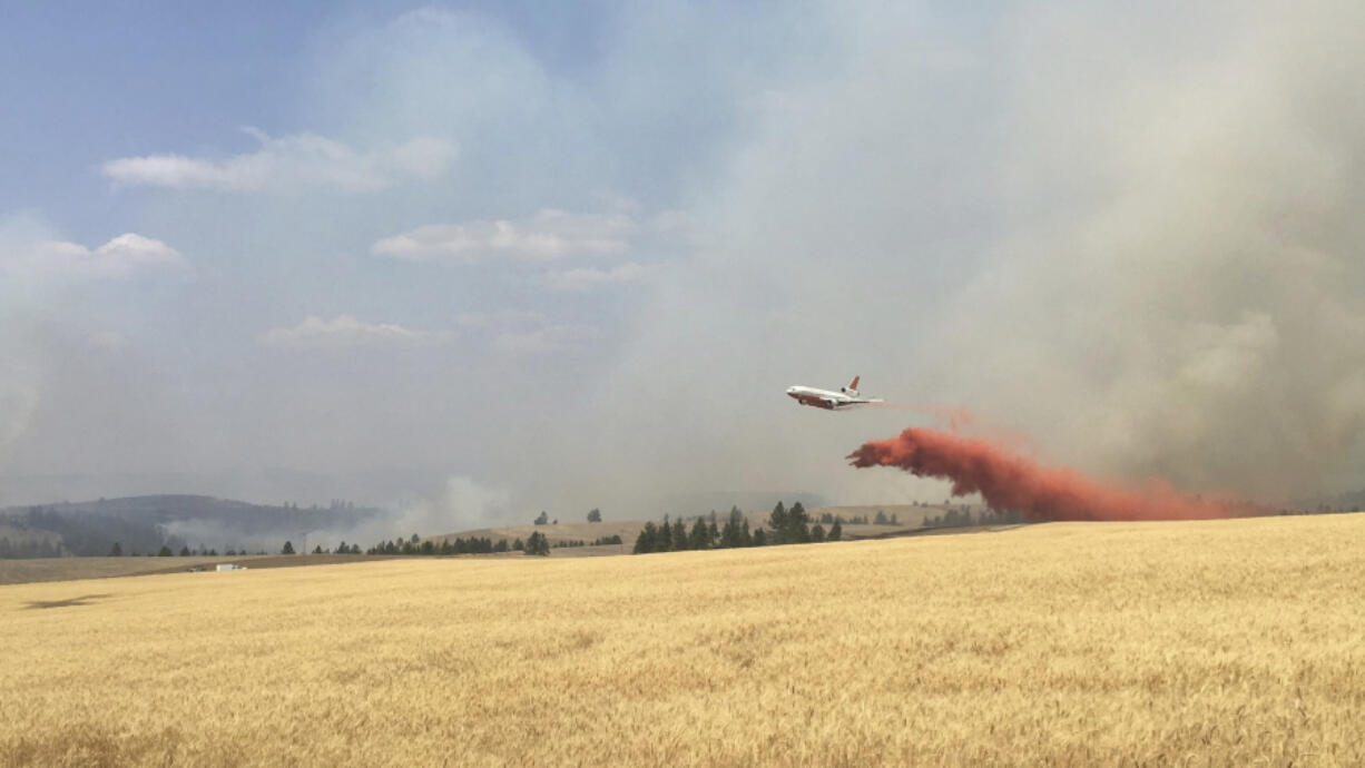 An air tanker drops retardant on a wheat field as crews battle a wildfire in eastern Washington in August.