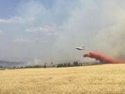 An air tanker drops retardant on a wheat field as crews battle a wildfire in eastern Washington in August.