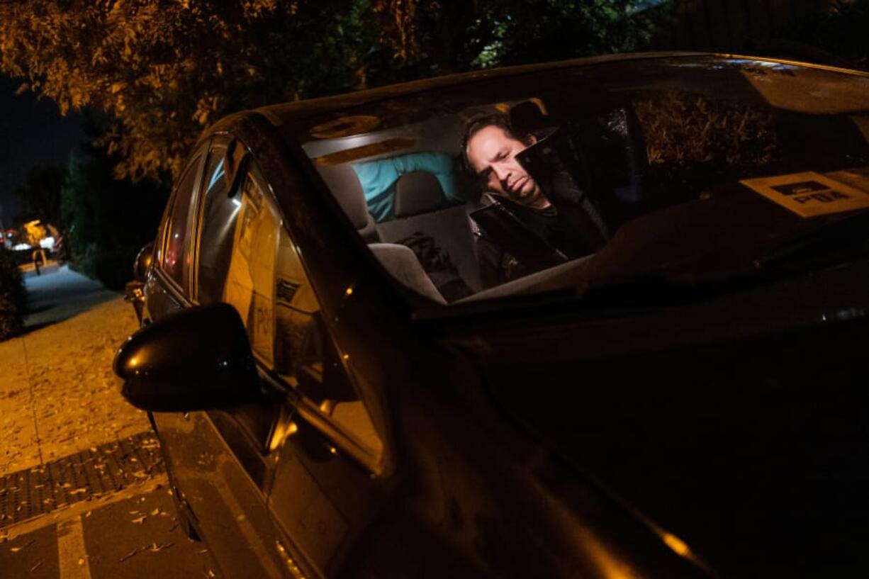 John, who gave only his first name to maintain his privacy about being homeless, readies his car for the night in the parking lot of WestGate Church.