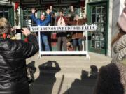 Joined by movie buffs, actor Brian Rohan, dressed as George Bailey, center, poses for photos during the It’s a Wonderful Life Festival in Seneca Falls, N.Y.