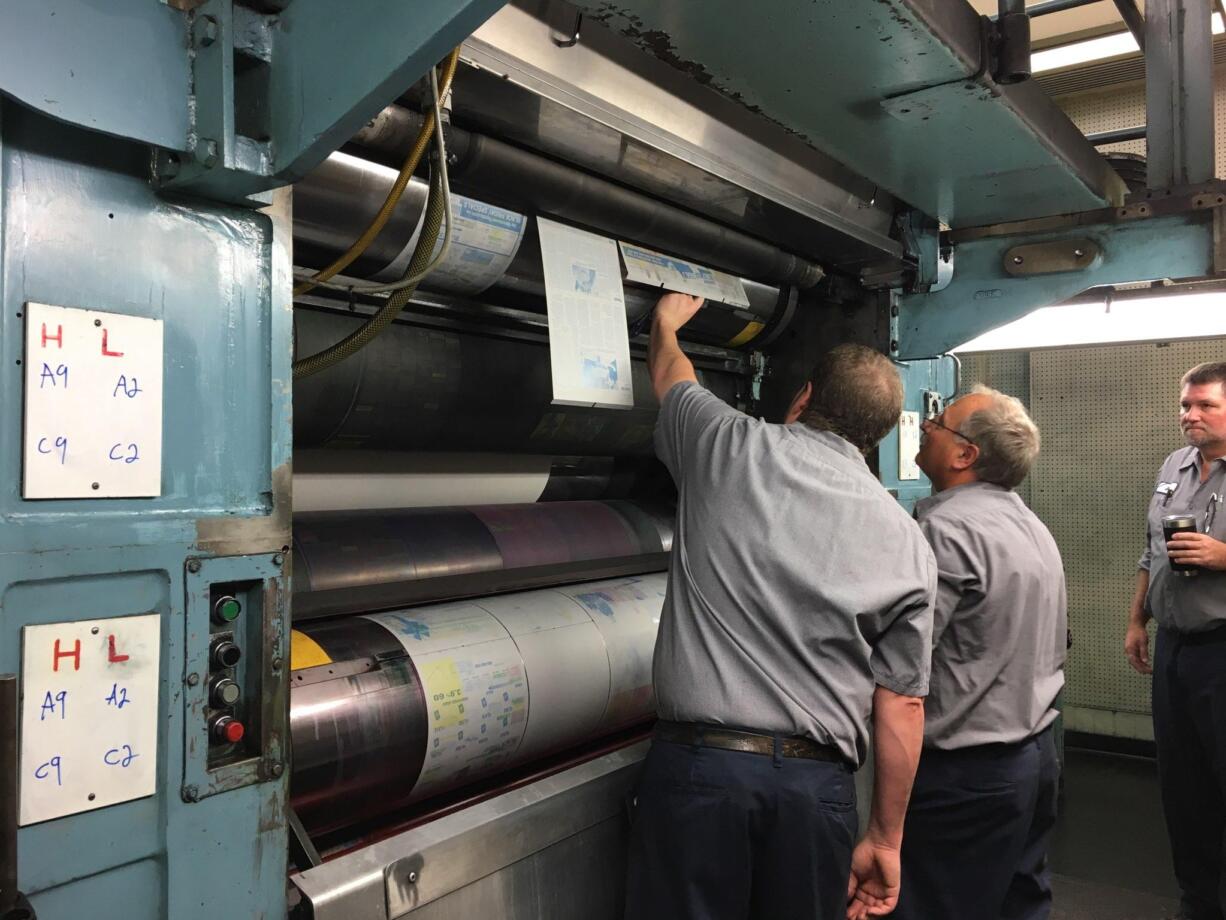 Pressmen work with plates on the printing press on the day before Thanksgiving.