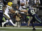 Green Bay Packers running back Aaron Jones, left, catches a pass for a touchdown, next to Seattle Seahawks outside linebacker Austin Calitro during the first half of an NFL football game Thursday, Nov. 15, 2018, in Seattle.