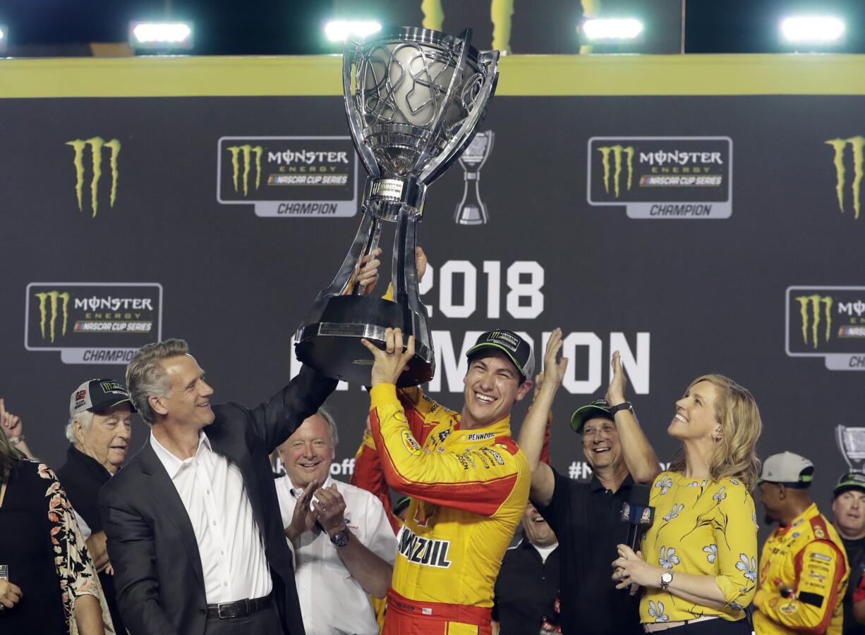 Joey Logano holds the trophy after winning the NASCAR Cup Series Championship auto race at the Homestead-Miami Speedway, Sunday, Nov. 18, 2018, in Homestead, Fla.