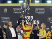 Joey Logano holds the trophy after winning the NASCAR Cup Series Championship auto race at the Homestead-Miami Speedway, Sunday, Nov. 18, 2018, in Homestead, Fla.