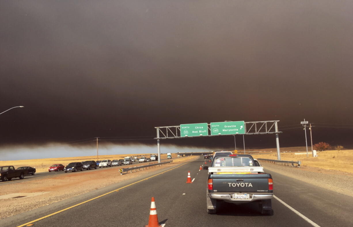 Smoke from the Camp Fire, burning in the Feather River Canyon near Paradise, Calif., darkens the sky as seen from Highway 99 near Marysville, Calif., Thursday, Nov. 8, 2018.