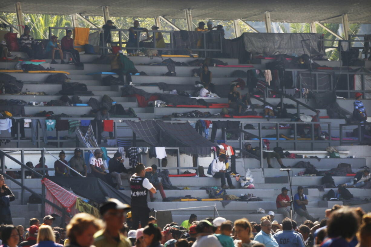 Central American migrants settle in Tuesday in the bleachers at Jesus Martinez stadium in Mexico City.