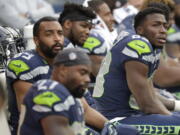 Seattle Seahawks players, including wide receivers David Moore, right, and Doug Baldwin, upper left, sit on the bench late in the second half of an NFL football game against the Los Angeles Chargers, Sunday, Nov. 4, 2018, in Seattle. (AP Photo/Ted S.