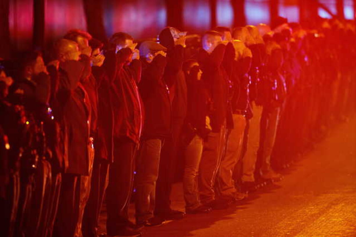 Police salute as an ambulance arrives at the medical examiner's office carrying the body of Chicago Police Department Officer Samuel Jimenez, who was killed during a shooting at Mercy Hospital earlier in the day, Monday, Nov. 19, 2018, in Chicago. (Armando L.