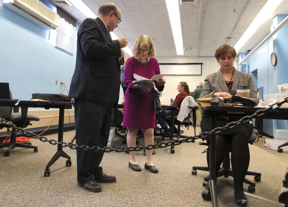 Maine election officials, including Democratic Secretary of State Matt Dunlap, left, and Deputy Secretary of State Julie Flynn, center, began counting ballots on Friday, Nov. 9, 2018, in Augusta for the Second Congressional District’s House election. The election is the first congressional race in American history to be decided by the ranked-choice voting method that allows second choices.