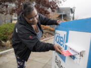 Sherita Cooks drops her ballot in a King County Elections ballot drop box on Election Day for the midterms Tuesday Nov. 6, 2018, in Burien, Wash.