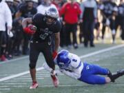 Union running back Isaiah Jones, left, sheds a tackle by Bothell defensive back Darius Kubalanza in the 4A state football quarterfinals.