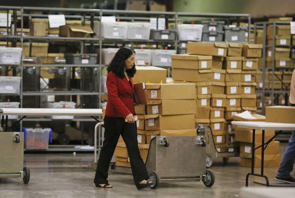 Susan Bucher, Supervisor of Elections walks near ballot boxes at the Palm Beach County Supervisor of Elections office during a recount on Wednesday, Nov. 14, 2018, in West Palm Beach, Fla.