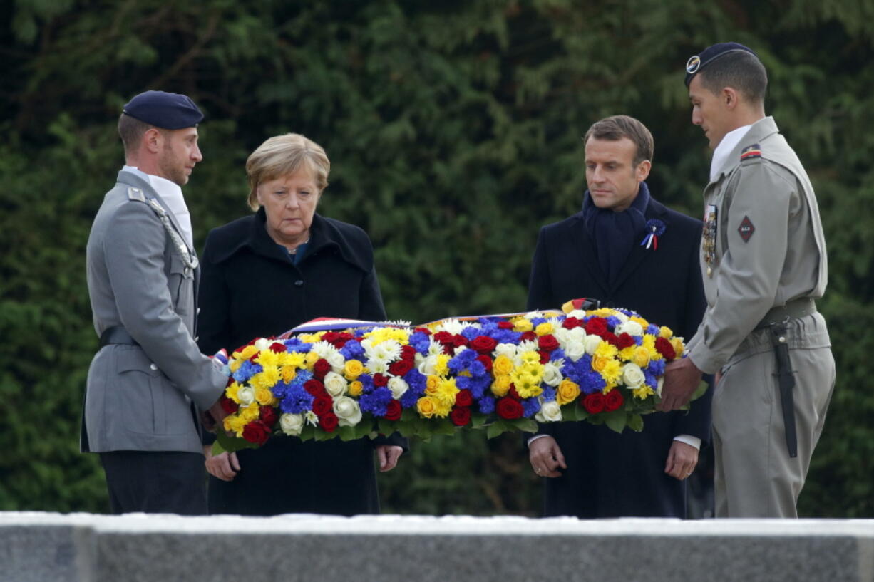 French President Emmanuel Macron and German Chancellor Angela Merkel lay flowers Saturday in the Clairiere of Rethondes in Compiegne, France, where the Armistice was signed in a railway carriage in the pre-dawn hours of Nov. 11, 1918.