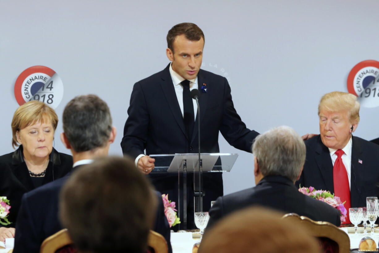 German Chancellor Angela Merkel and President Donald Trump listen to French President Emmanuel Macron delivering a speech before a lunch at the Elysee Palace in Paris during commemorations marking the 100th anniversary of the 11 November 1918 armistice, ending World War I, Sunday, Nov. 11, 2018.