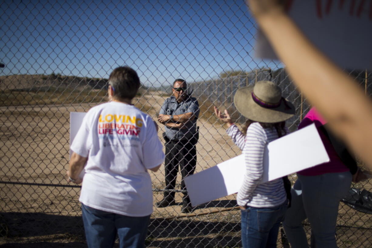 In this Nov. 15, 2018 photo provided by Ivan Pierre Aguirre, protesters talk to a guard inside the Tornillo detention camp holding more than 2,300 migrant teens in Tornillo, Texas. The Trump administration announced in June 2018 that it would open the temporary shelter for up to 360 migrant children in this isolated corner of the Texas desert. Less than six months later, the facility has expanded into a detention camp holding thousands of teenagers - and it shows every sign of becoming more permanent.