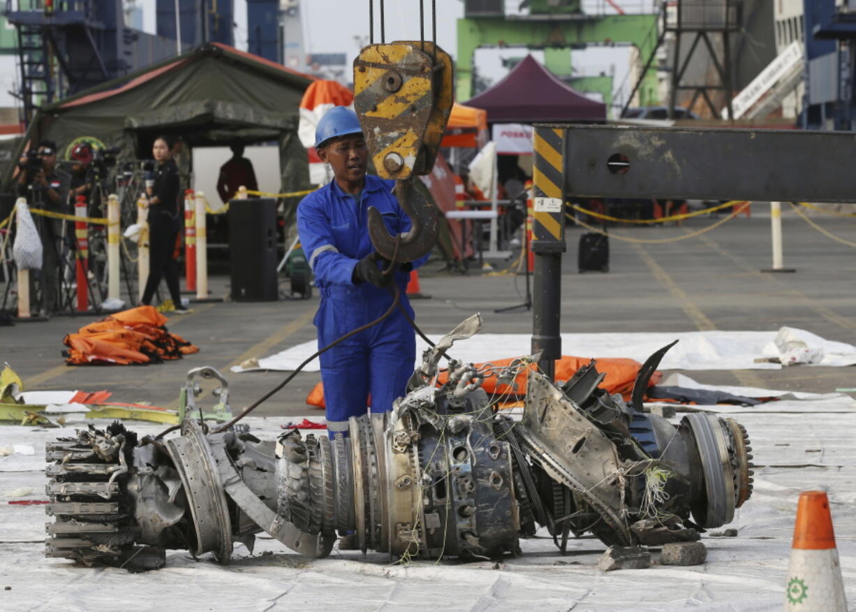 Officials move an engine recovered from the crashed Lion Air jet for further investigation in Jakarta, Indonesia, Sunday, Nov. 4, 2018. The brand new Boeing 737 MAX 8 jet plunged into the Java Sea just minutes after takeoff from Jakarta early on Oct. 29, killing all of its passengers on board.