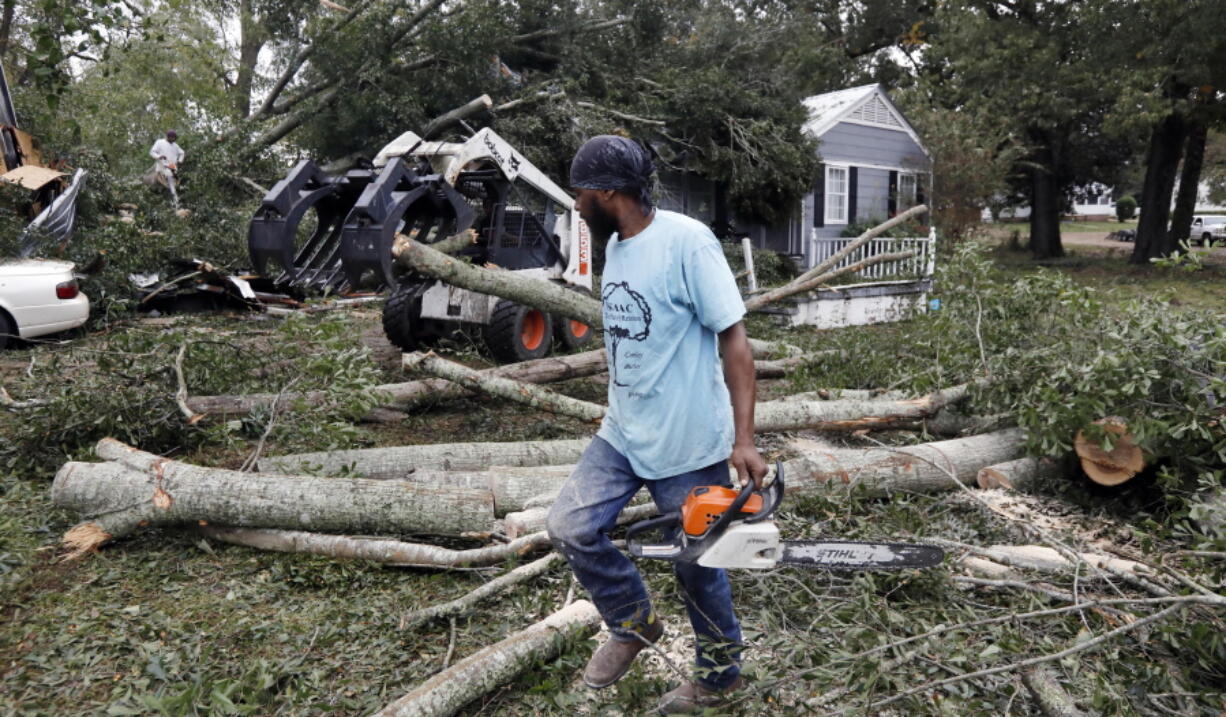 The sound of chainsaws grind through a neighborhood in Natchez, Miss., as cleanup begins following a tornado that hit early Thursday. At least 11 tornadoes have been confirmed by National Weather Service surveyors so far in Louisiana and Mississippi as part of a storm system that moved across the region Wednesday night and Thursday. (AP Photo/Rogelio V.