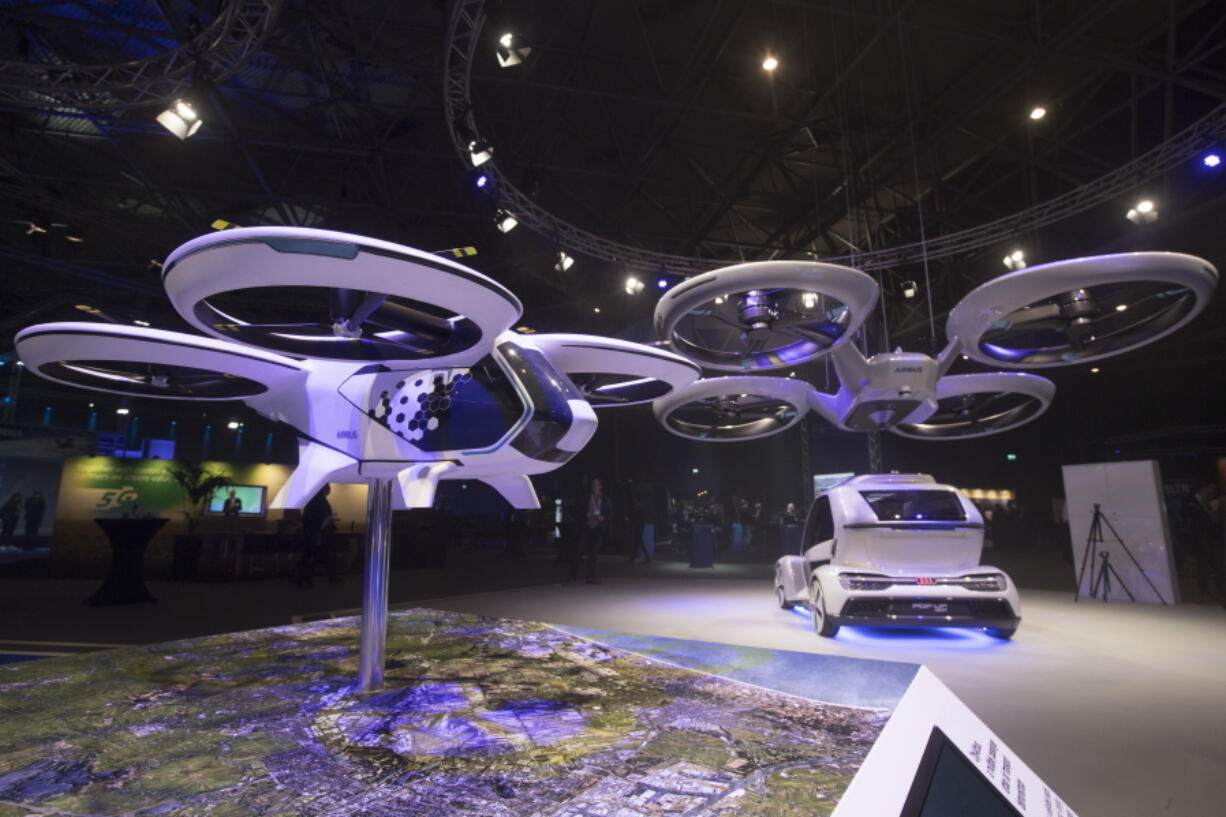 An Airbus passenger drone and Pop.Up Next, rear, a prototype designed by Audi, Airbus and Italdesign is displayed at the Amsterdam Drone Week in Amsterdam, Netherlands, Tuesday, Nov. 27, 2018. The Pop.Up Next, a two-seater vehicle, combines combines ground transportation with vertical take-off and landing.