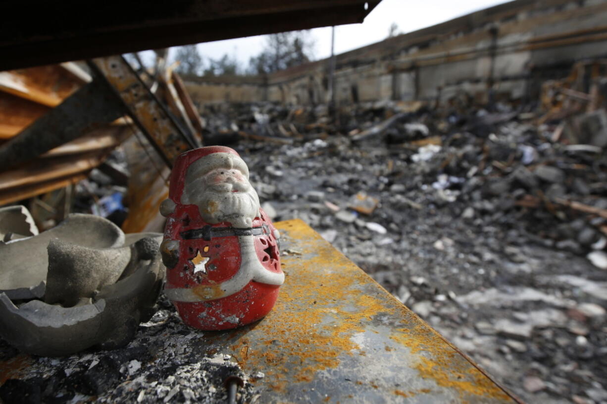 A Christmas decoration sits among the burned ruins of a store in Paradise, Calif., on Monday. A wildfire called the Camp Fire tore through the Northern California town killing dozens and destroying thousands of homes and businesses.