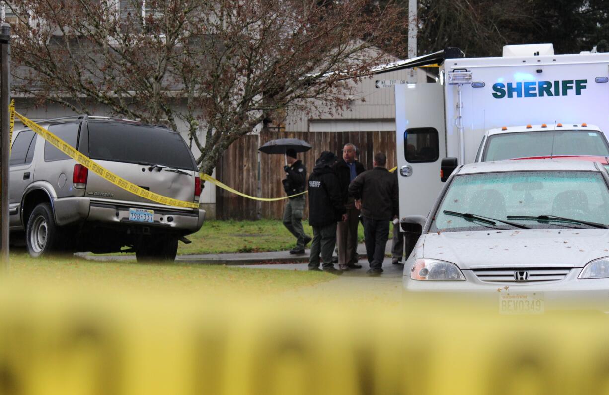 Investigators gather at the scene of a deputy-involved shooting Wednesday morning in the Orchards area. A deputy was rammed by a vehicle theft suspect and a shooting occurred.