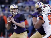 Washington quarterback Jake Browning, left, drops back to pass against Oregon State in the first half of an NCAA college football game Saturday, Nov. 17, 2018, in Seattle.