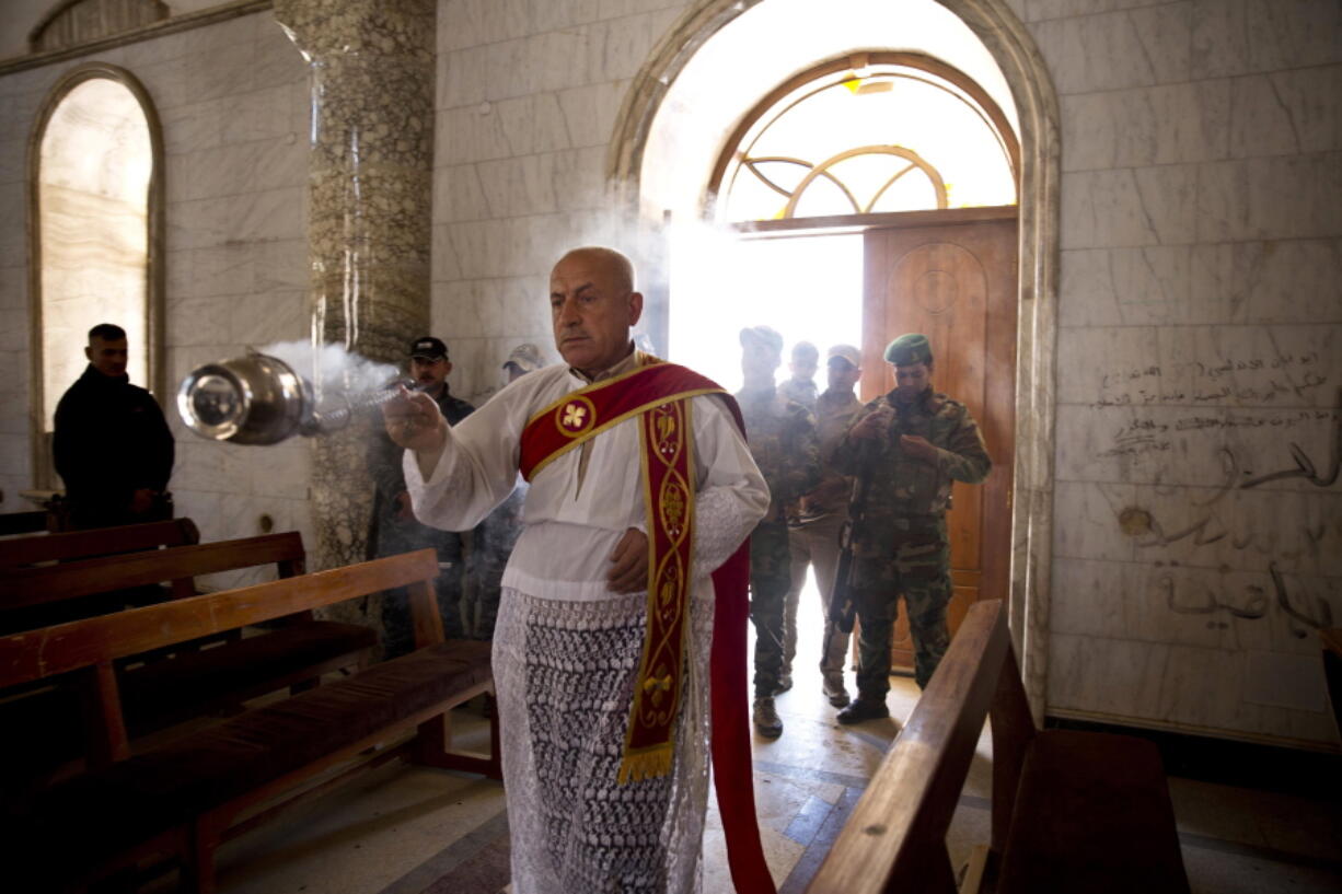 Christian militiamen stand guard in 2017 during Easter mass in Qaraqosh, outside Mosul, Iraq. Synagogues, mosques, churches and other houses of worship are routinely at risk of attack in many parts of the world. And so worshippers themselves often feel the need for visible, tangible protection even as they seek the divine.