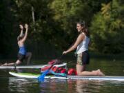 Teacher Angie Cherry, right, keeps an eye on the class while leading them through their yoga poses Thursday afternoon at Round Lake. Cherry will continue to teach some classes at Body Bliss Yoga Studio in Washougal, even after she transfers operations to teacher Jacquie Michelle.