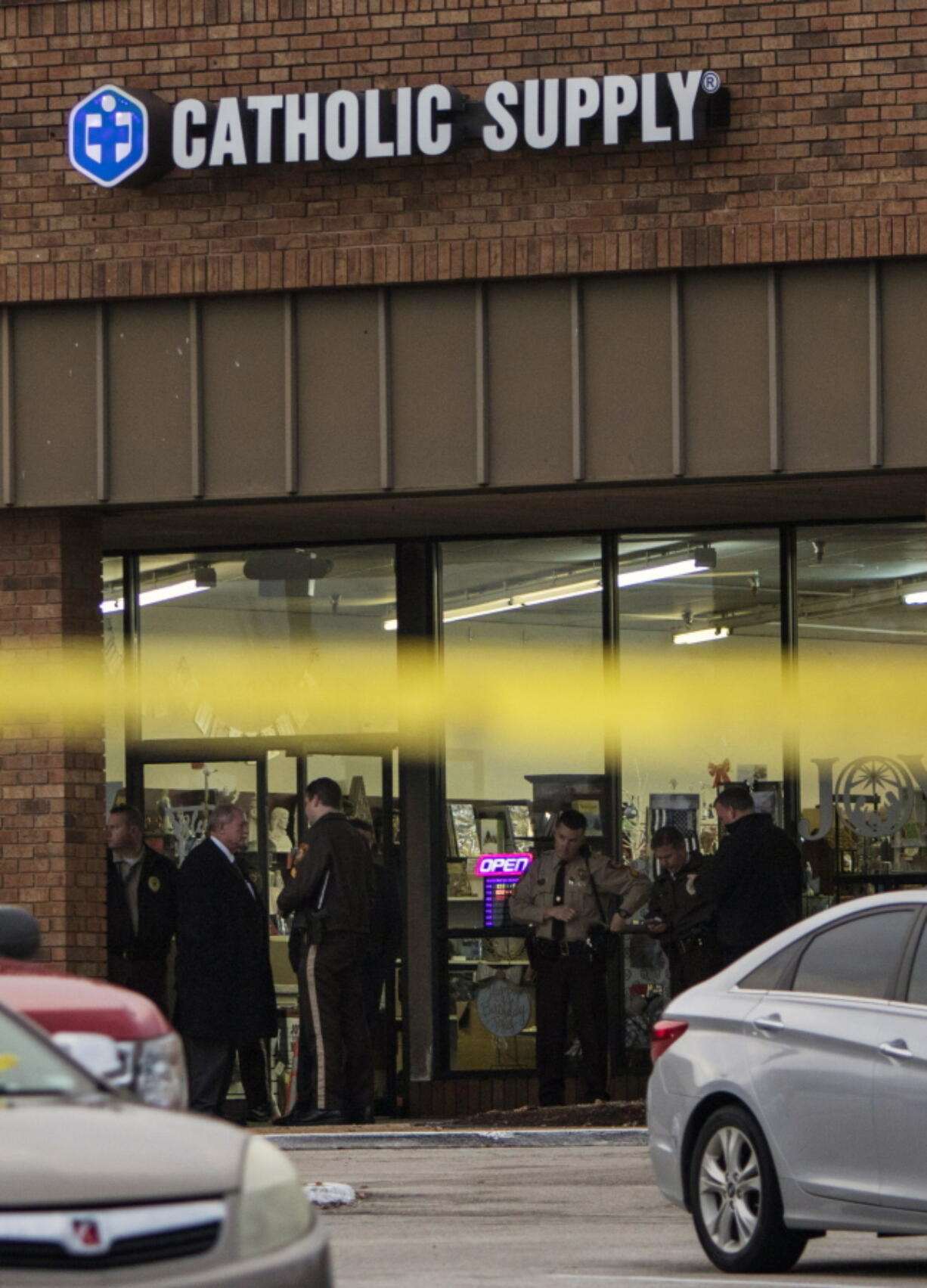 Authorities investigate the scene at a Catholic Supply store where a gunman went into the religious supply store, sexually assaulted at least one woman and shot a woman in the head, Monday in Ballwin, Mo. (Johanna Huckeba/St.