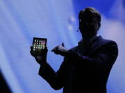 Justin Denison, SVP of Mobile Product Development, shows off the Infinity Flex Display of a folding smartphone during the keynote address of the Samsung Developer Conference Wednesday, Nov. 7, 2018, in San Francisco.