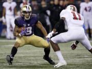 Washington's Myles Gaskin (9) carries as Stanford's Paulson Adebo moves in during the first half of an NCAA college football game Saturday, Nov. 3, 2018, in Seattle.