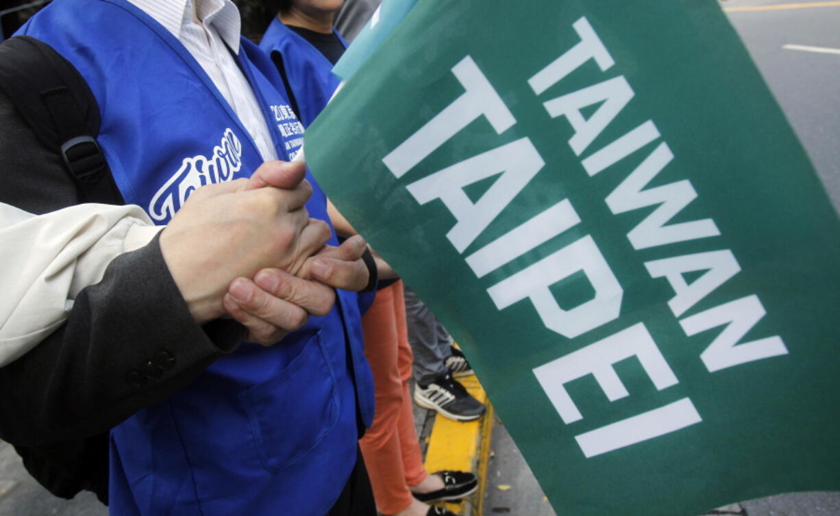 Supporters hold hands and a flag with the words “Taiwan Taipei” during a rally for a referendum asking if national teams, including ones for the Olympics, should go by the name “Taiwan Taipei” instead of “Chinese Taipei” in Taipei, Taiwan. Taiwan will vote on a referendum this month asking if the self-ruled island should compete as “Taiwan” instead of the present “Chinese Taipei.” This would include the 2020 Olympics in Tokyo. The controversial referendum has angered China, which sees Taiwan as a breakaway province.