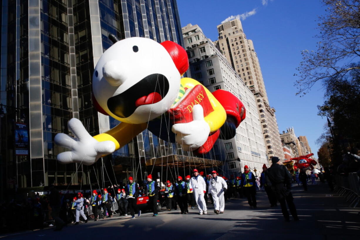 Greg Heffley from the “Diary of a Wimpy Kid” series balloon passes by windows of a building on Central Park West during the 92nd annual Macy’s Thanksgiving Day Parade in New York, Thursday, Nov. 22, 2018.