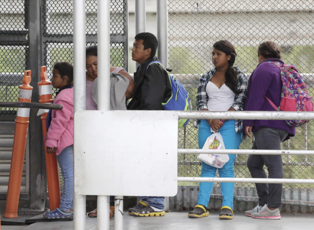 People seeking asylum in the United States wait in line on the Inter-national Bridge on Saturday in Reynosa, Mexico.