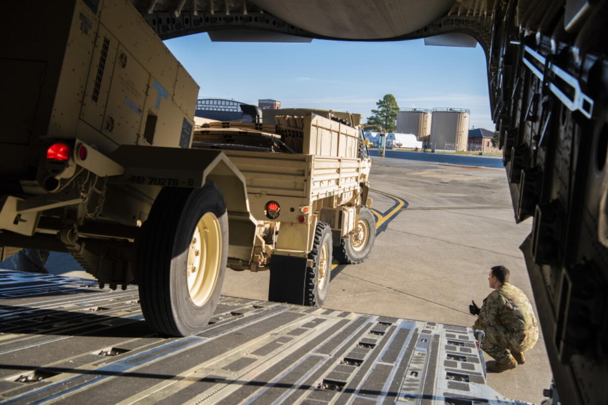 This Oct. 29, 2018 photo provided by the U.S. Air Force shows Airman 1st Class Trevor Pearce helping guide a military vehicle into the cargo compartment of a C-17 Globemaster III at Fort Knox, Kentucky. The aircrews provided strategic airlift to Headquarters Company, 89th Military Police Brigade, Task Force Griffin, which is deploying to the Southwest border region to support law enforcement agencies as they conduct coordinated efforts to secure the border. (Airman 1st Class Zoe M. Wockenfuss/U.S.