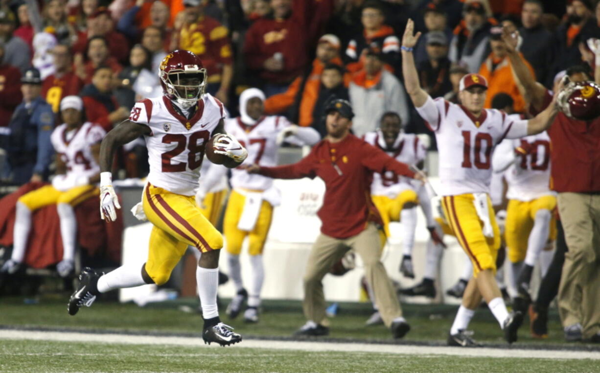 Southern California’ Aca’Cedric Ware (28) races past his bench on a 57-yard touchdown run in the first half of an NCAA college football game against Oregon State in Corvallis, Ore., on Saturday, Nov. 3, 2018. (AP Photo/Timothy J.