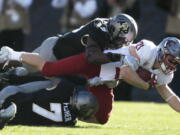 Washington State running back Max Borghi, center, is tackled after a short gain by Colorado linebacker Davion Taylor, top, and defensive back Nick Fisher in the first half of an NCAA college football game Saturday, Nov. 10, 2018, in Boulder, Colo.