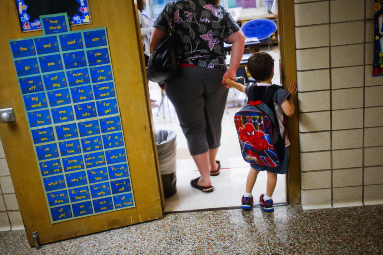 A reluctant student is pulled into the first day of kindergarten in 2015 at an elementary school in Clio, Mich. A study shows the youngest children in a class are more likely to be diagnosed with attention deficit hyperactivity disorder.