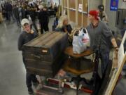 Teirsa Belvin, left, and Dana Walkinshaw, center, negotiate their purchases of some furniture at the NW’s Largest Garage Sale in 2018.