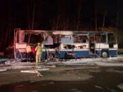 Firefighters inspect the remains of a motor home destroyed in a fire Tuesday night at the southbound Gee Creek rest area off Interstate 5.