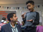 Adam Aguilera helps fourth-grader Kaler Mathews with a question about a math exercise during class at Pioneer Elementary School on Nov. 5 in Vancouver. Aguilera, who is Latino, said his own identity informs his teaching and helps him relate to his students of color on a meaningful level.