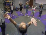 Kaliah Matthews, 8, stretches at the beginning of a community education yoga class at Union Ridge Elementary School in Ridgefield. Kaliah’s mother, Kristen, teaches the yoga class at Union Ridge. A national study shows that yoga and meditation are rising in popularity among children ages 4 through 17.