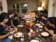 Leesa Holder,center, recounts her family’s experience as they tried to reunite and escape the fire that destroyed Paradise, Calif., in November. Holder and her two children, Dominick Brown, third from left, 13, and Amber Brown, third from right, 14, came to live with the family of Battle Ground’s Lois Ivanoff, left, after they were displaced by the fire.