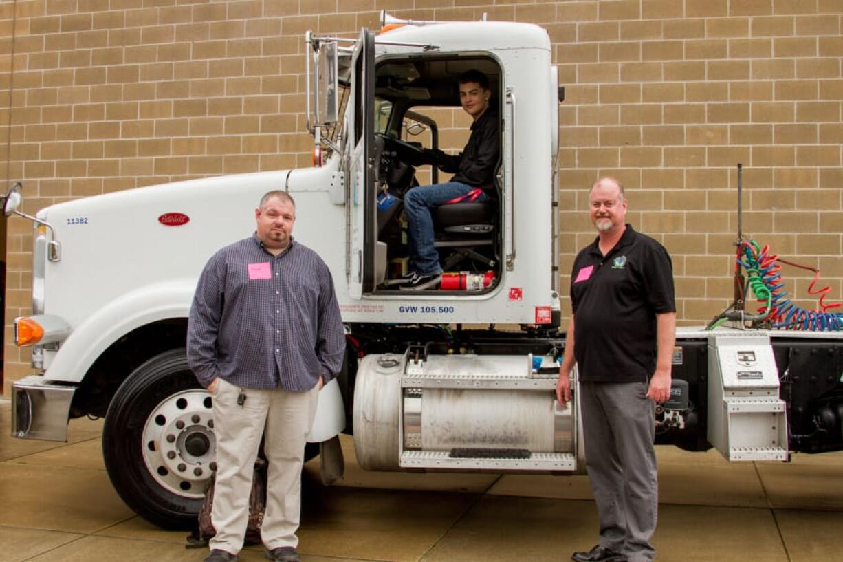 Woodland: Tribeca Transport truck driver Brad Cushman, and Eric Thwaites, chief operating officer, right, show Woodland High School student Shaun Sadlier, center, some of the features of one of their tractor trailers at the inaugural Woodland Days Career Fair, organized by Woodland Public Schools and the Port of Woodland.