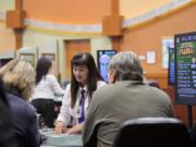 Dealer Sandy Pham looks over cards while assisting players at The Last Frontier Casino. The casino has about 200 employees.