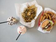 The chili cheese fries, top center, the Bacon and Bleu Cheeseburger and onion rings, right, the Candy Cane Shake, bottom, and the Tropical Monkey Shake, left, are seen at K&M Drive-In in Camas.