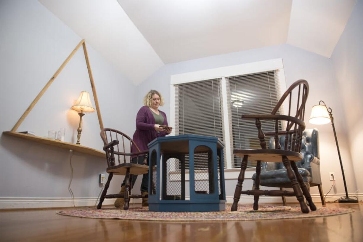 Co-owner Sophie Wegecsanyi sorts through angel oracle cards while rearranging an upstairs room used for card readings and moon ceremonies. The relocated Wattle Tree Place is still a work in progress.