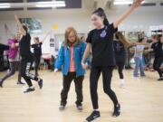 Hannah Roberts, left, is led through the steps of a dance performance by 14-year-old Victoria Self during a rehearsal at Heritage High School.